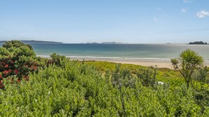 A coastal landscape with a beach, greenery, and distant islands. - Double the Beach - Opito Bay Holiday Home (Opito Bay)
