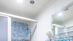 Une salle de bain avec douche, toilettes et lavabo.