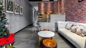A modern living room with a sofa, coffee table, and a Christmas tree.