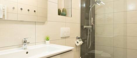 A modern bathroom with a large sink, toilet, and shower.