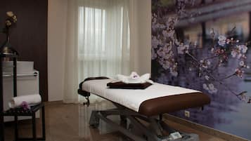 Experience tranquility in this serene spa room, featuring a massage table, footrest, and soothing ambiance.