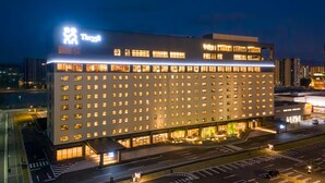 Ein modernes Hotel mit auffälligem Logo, mehreren Stockwerken und einer gut beleuchteten Fassade.