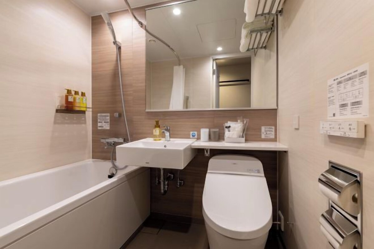 A modern bathroom with a bathtub, sink, and toilet.
