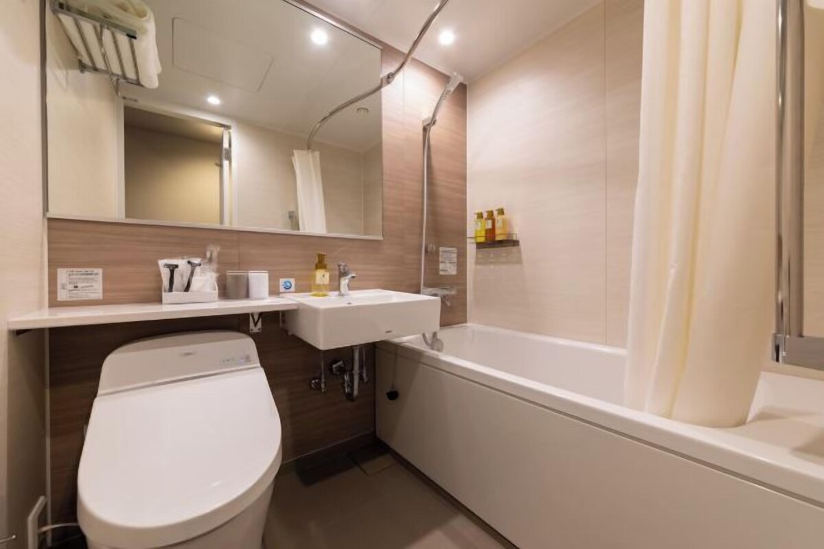 A modern bathroom with a toilet, sink, and bathtub.