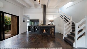 Ein modernes Interieur mit Kamin, Holzboden und Treppe.