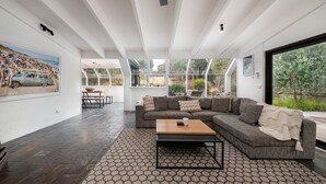 Ein modernes Wohnzimmer mit einer großen Eckcouch, einem Couchtisch und einem Essbereich mit Holztisch und Stühlen.