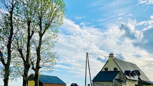 Een landweg naar een stenen boerderij, met een bord waarop ‘La Pave’ staat.