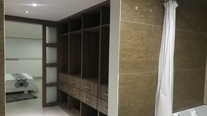 Ein modernes Schlafzimmer mit integriertem Kleiderschrank, Nachttisch und Duschbereich.
