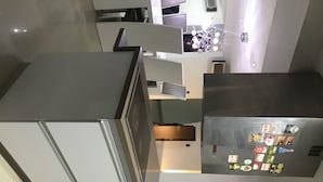 Eine moderne Küche mit Edelstahlgeräten, einem Backofen und einem Kühlschrank mit Magneten.
