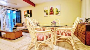 A dining area with wicker chairs, a glass table, and a sofa. - Nice Apartment, Equipped Near the Malecon and the Beach (La Paz)