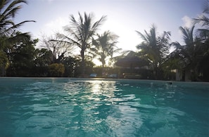 A swimming pool surrounded by palm trees with a clear sky. - Deluxe Villa With Garden / Pool With Service Staff 150mt From the sea (Watamu)