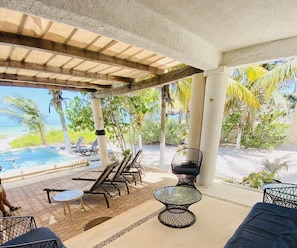A covered outdoor area with lounge chairs, a pool, and tropical vegetation. - Entire House on the Seashore in Chicxulub Puerto, Yuc, Riviera Yucateca Mex (Progreso)
