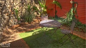 A patio with a stone wall, a red fence, and potted plants. - Cherry Lane Self Catering and BB - Romantic Honeymoon Suite for 2 Bloemfontein (Bloemfontein)