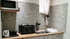 A compact kitchen with a microwave, toaster, and sink. - Cozy Triple Room With King Sized bed and Single Bed, Near Bloemfontein (Bloemfontein)