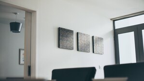 A modern room with a minimalist design, featuring a large window, a hanging light fixture, and three framed artworks on the wall. - Henry Street - Apt 22 (Liverpool)
