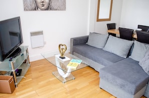 Relax in this stylish living room with a sofa, coffee table, and flat-screen TV.
