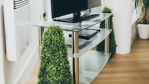 A modern living room with a flat-screen TV on a glass console, a potted plant, and a radiator. - Kent Street - Apt 14 (Liverpool)