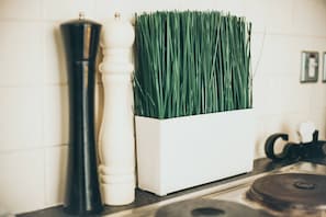 A kitchen counter with a white spice rack holding green herbs and a black pepper mill. - Kent Street - Apt 15 (Liverpool)