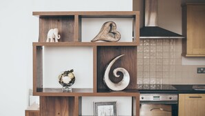 A wooden shelf with decorative items including a heart, an elephant, and a spiral design. - Kent Street - Apt 17 (Liverpool)