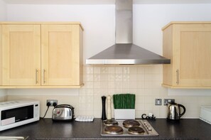 Apartamento, 2 quartos | Cozinha privada | Geladeira, micro-ondas, fogão, cooktop