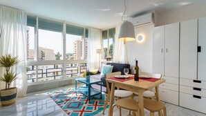 Un appartement moderne doté d’un coin repas, d’un canapé et offrant une vue sur la ville.