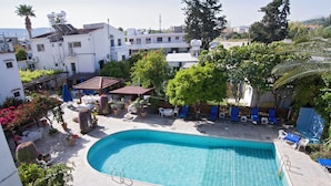 A swimming pool with a tiled deck, surrounded by potted plants and outdoor furniture. - Room-one Bedroom Apartment - Just 800 m (Polis)