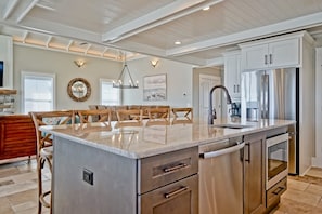 A spacious kitchen with a large island, stainless steel appliances, and a modern design. - Cinnamon Sands 6 Bedroom Home by RedAwning (Supply)