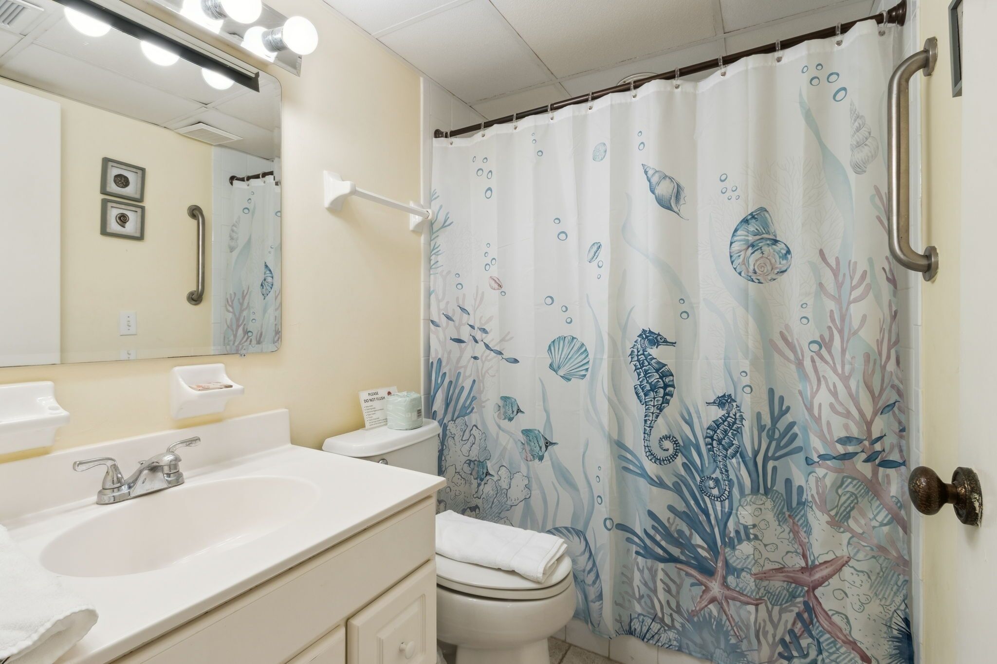 A bathroom with a white sink, mirror, and toilet.