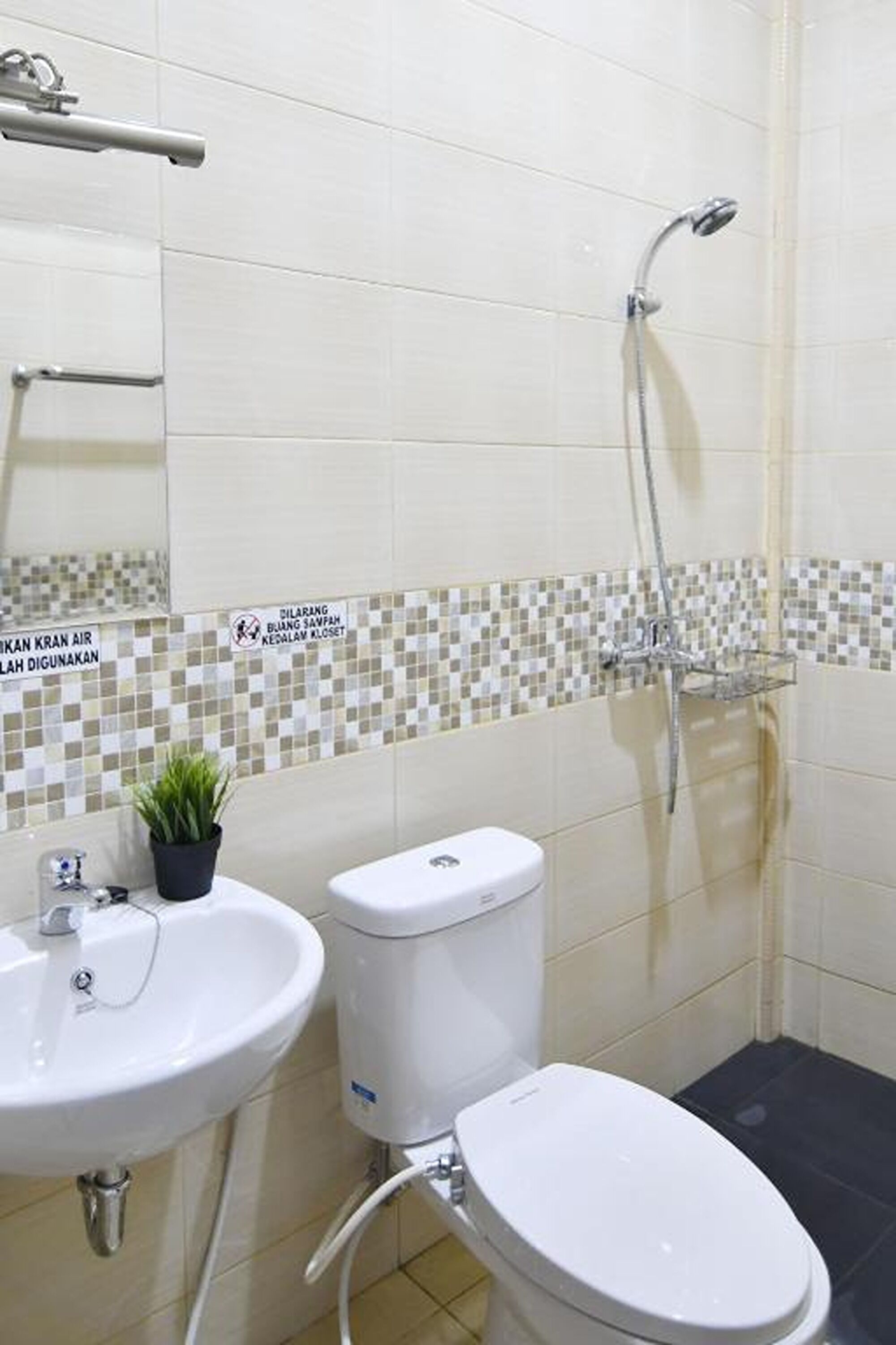 A bathroom with a toilet, sink, and shower.
