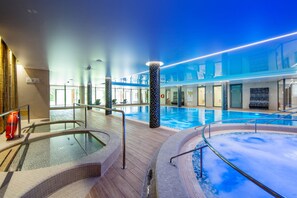 An indoor swimming pool with multiple lanes, a hot tub, and a lifeguard stand. - Sopotorium Hotel & Medical Spa (Sopot)