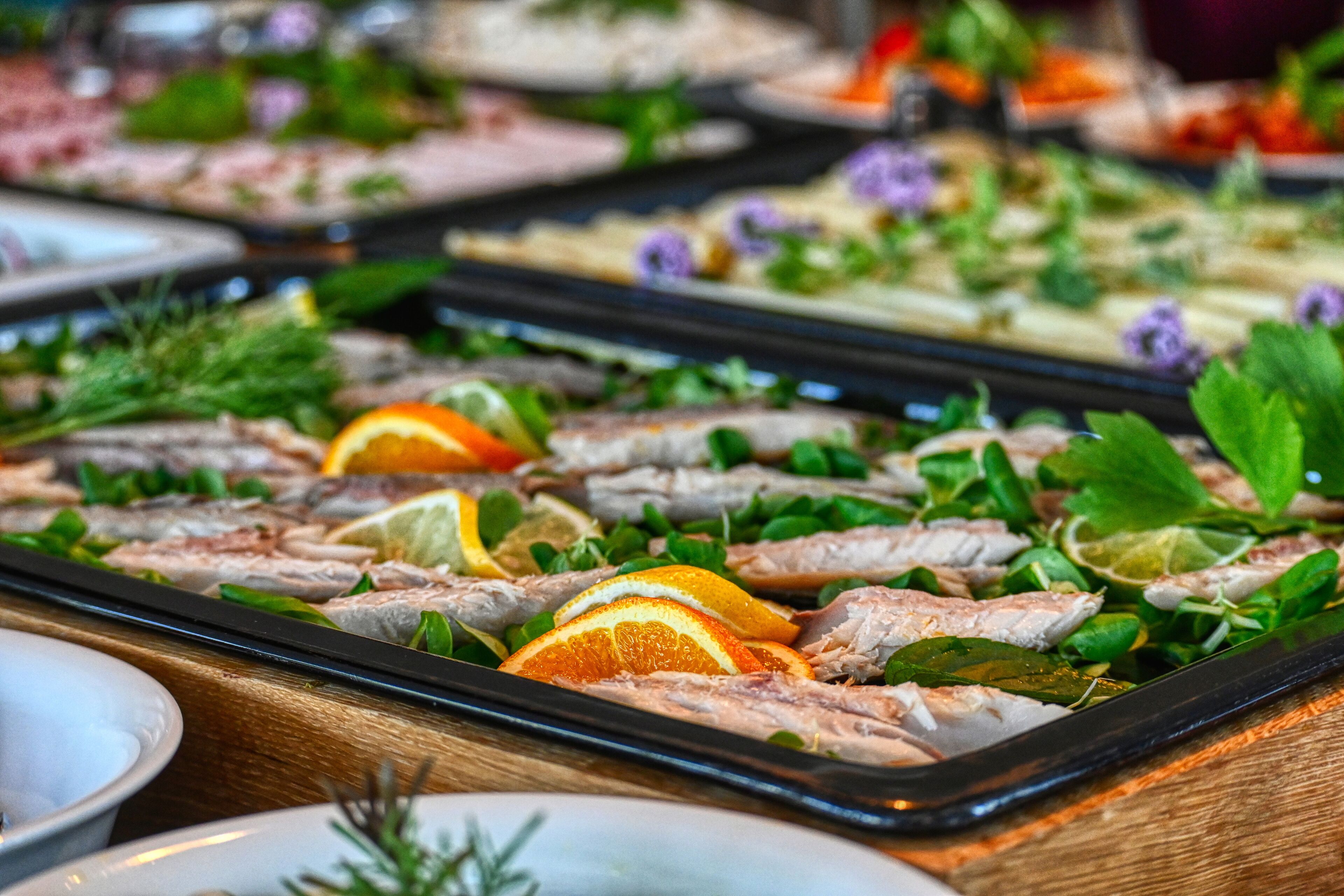 A buffet with various dishes, including seafood and garnishes.