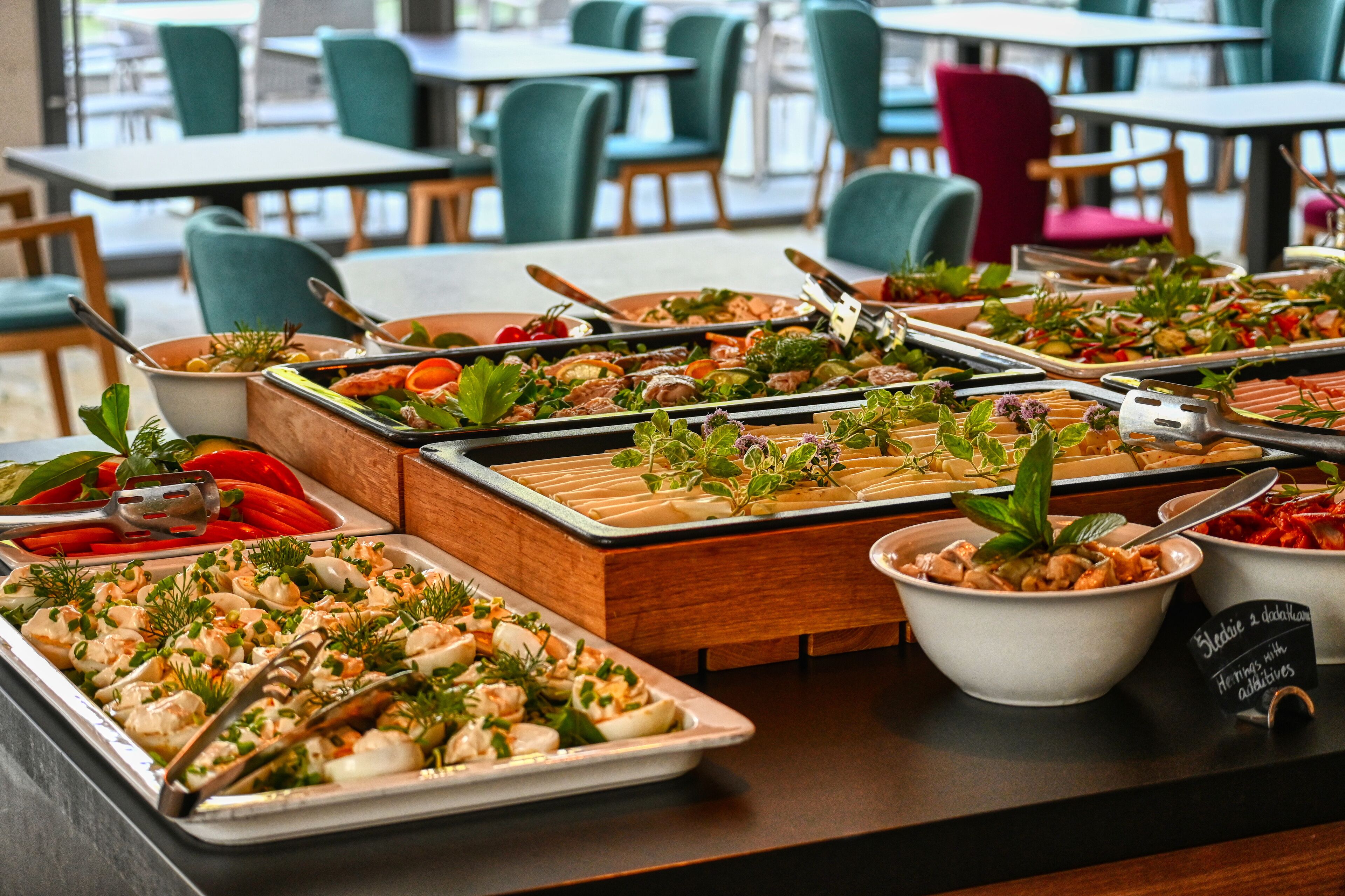 Una mesa de buffet con diversos platos, incluyendo mariscos y ensaladas, dispuestos en bandejas y tazones.