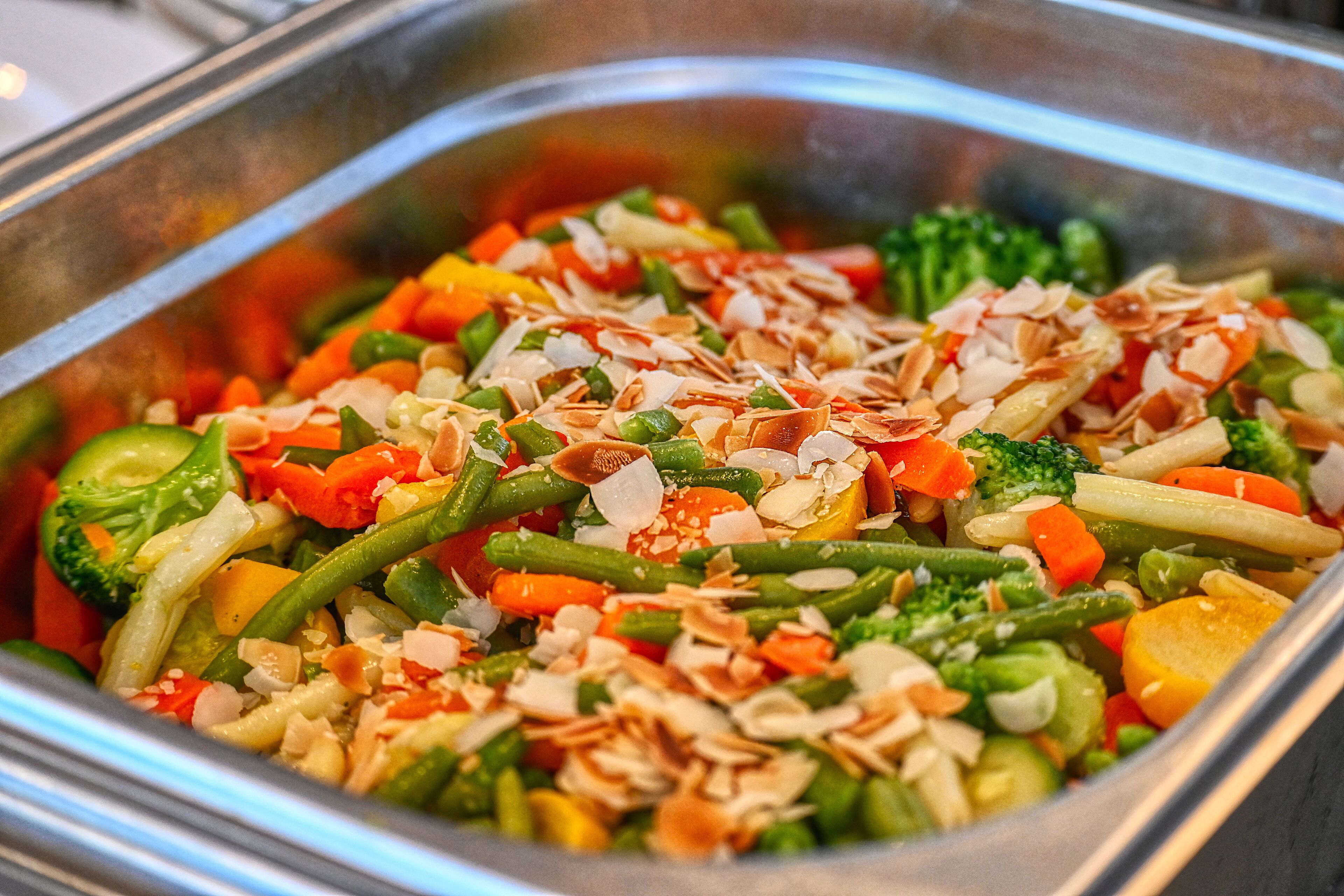 A buffet with a variety of vegetables and nuts.