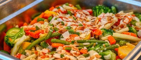 A buffet with a variety of vegetables and nuts.