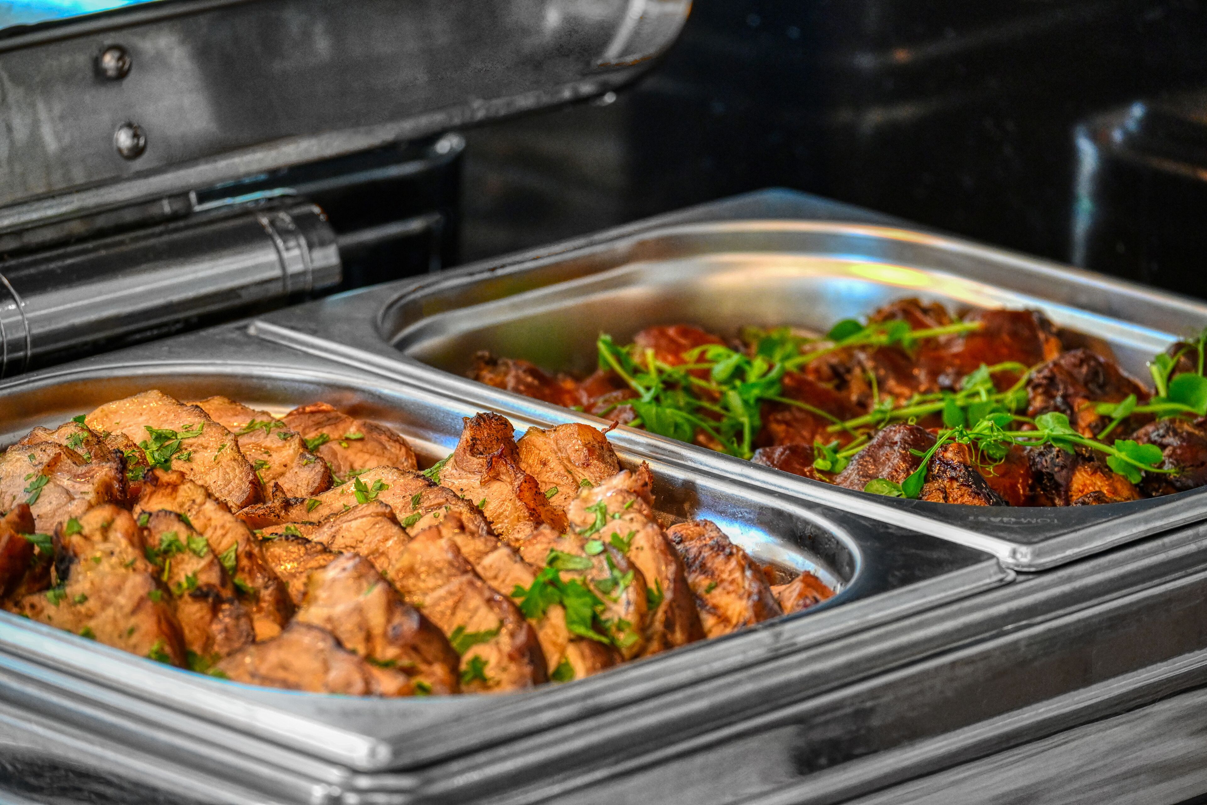A buffet with various dishes, including sliced meat and garnished items.