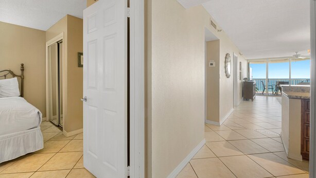Une chambre d’hôtel avec un lit, une porte, une salle de bain et un balcon offrant une vue.