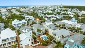 A coastal residential area with multiple two-story houses, a clear view of the ocean, and a prominent water tower in the distance.