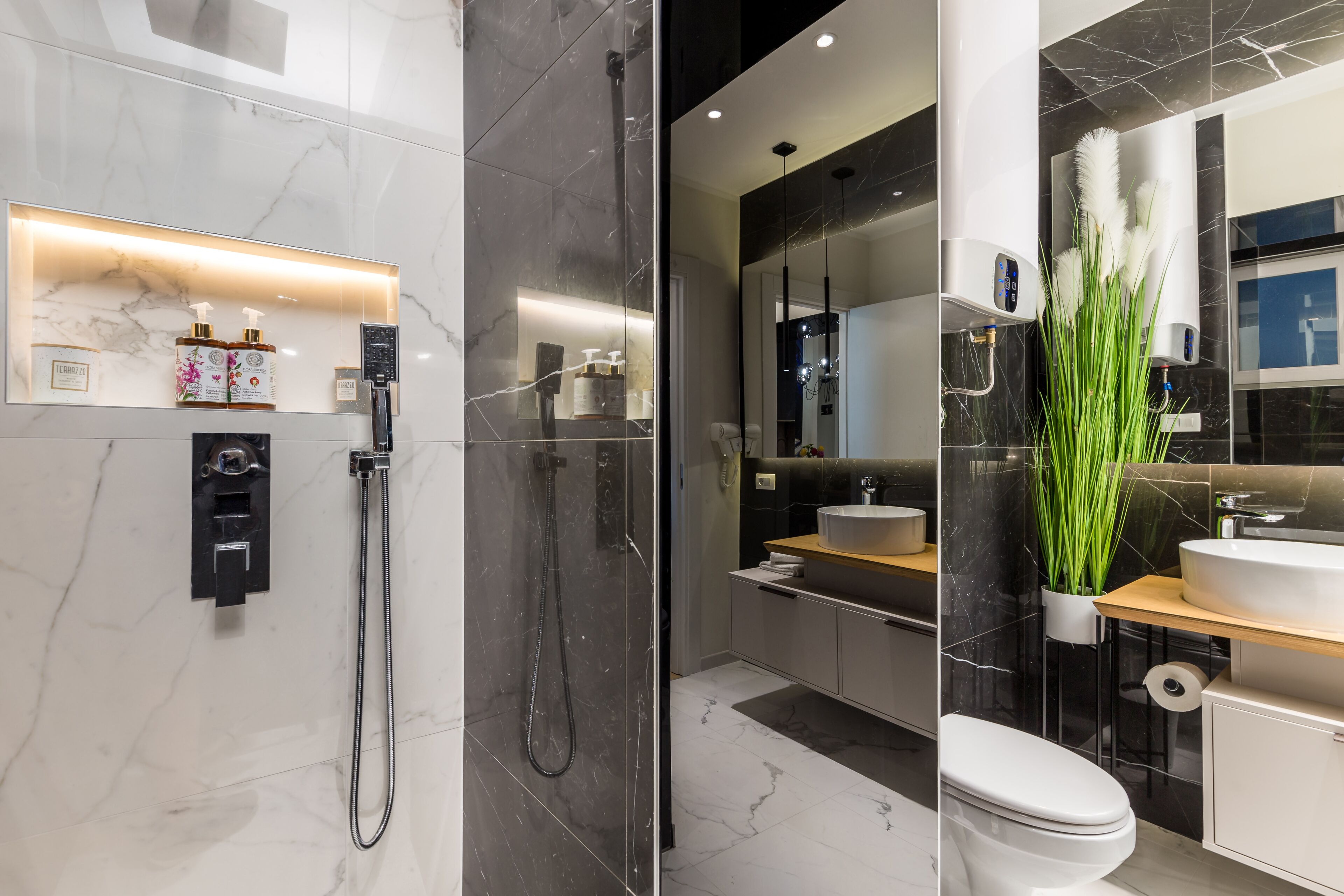 Un baño moderno con cabina de ducha de vidrio, tocador con lavamanos y inodoro.