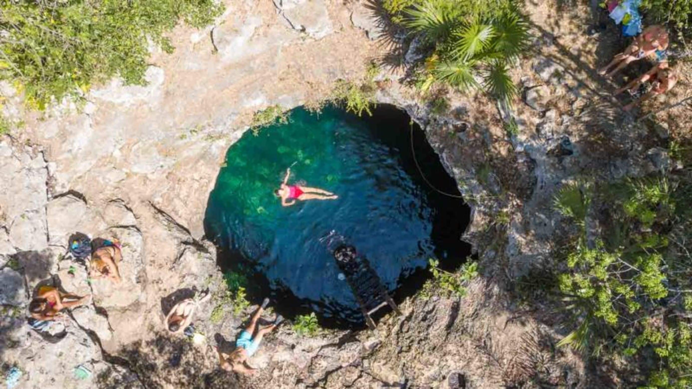 A circular natural pool surrounded by rocky terrain and sparse vegetation.