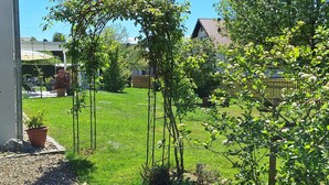A well-maintained garden with a lawn, a pergola, and a wooden fence. - On the Allgäu cycle path, quiet apartment, with bicycle garage (Lachen-Hetzlinshofen)