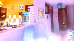 A kitchen with a gas stove, a water dispenser, and a refrigerator. - Amazing House of View (San Cristóbal de las Casas)