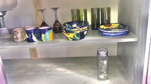 A shelf with various ceramic items, including mugs, vases, and a decorative bowl. - Cozy Big Bungalow Close To Downtown (San Cristóbal de las Casas)