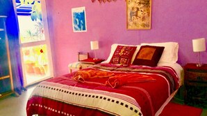 Ein Schlafzimmer mit einem großen Bett, zwei Nachttischen und einem Fenster mit Aussicht.