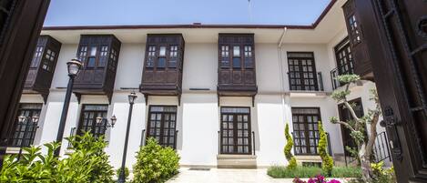 Un edificio con fachada simétrica, varios ventanales y una entrada central con un diseño decorativo en el suelo.