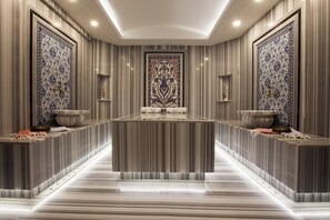 A luxurious hotel lobby with a marble reception desk, ornate wall panels, and a central decorative piece. - Livia Garden Hotel (Selçuk)