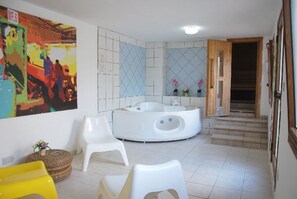 A bathroom with a freestanding bathtub, white chairs, and a colorful abstract painting. - Exceptional Large Villa, Free Heated Pool 1 NOV - 15 Jan, Privacy,prime Location (Pegeia)