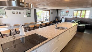 A kitchen with a granite countertop, stainless steel appliances, and a built-in stove. - 5 Star Holiday Home in Roslev (Roslev)