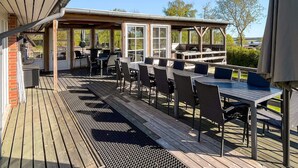 An outdoor patio with a covered seating area, a grill, and a view of the surrounding landscape. - 5 Star Holiday Home in Roslev (Roslev)