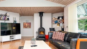 A modern living room with a flat-screen TV, a fireplace, a sofa, and a coffee table.