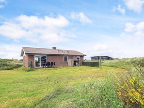A single-story brick house with a patio and a covered outdoor seating area. - 7 Person Holiday Home in Frostrup (Frøstrup)